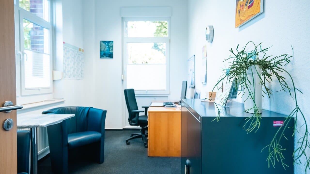 Helles Beratungsbüro im Kreis Borken mit Schreibtisch, Computer und Sitzplätzen für Unterstützungsangebote bei psychischer Erkrankung.