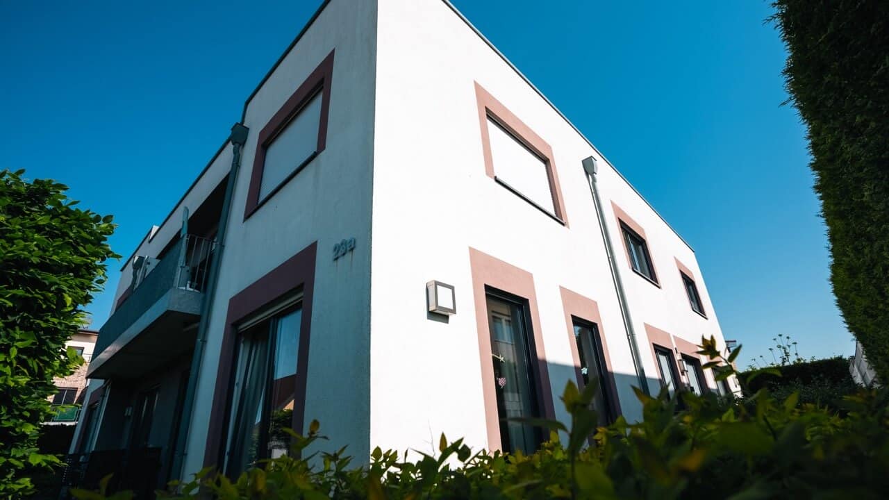 Mehrere Menschen unterhalten sich vor einem Beratungszentrum für psychische Gesundheit im Kreis Borken bei Sonnenschein.