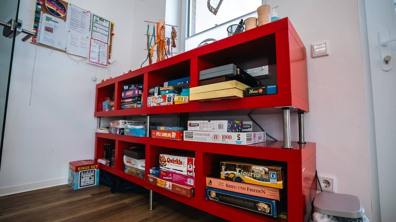 Zwei rote Regale mit Gesellschaftsspielen und Puzzles als Unterstützungsangebote für psychische Kranke im Kreis Borken.